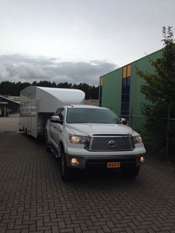 Vooraanzicht van witte gesloten trailer van Fifthwheel achter een Toyota Hilux