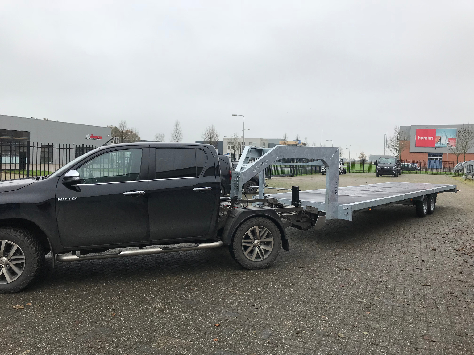 Zwarte Toyota Hilux met aluminium vlakke wagen
